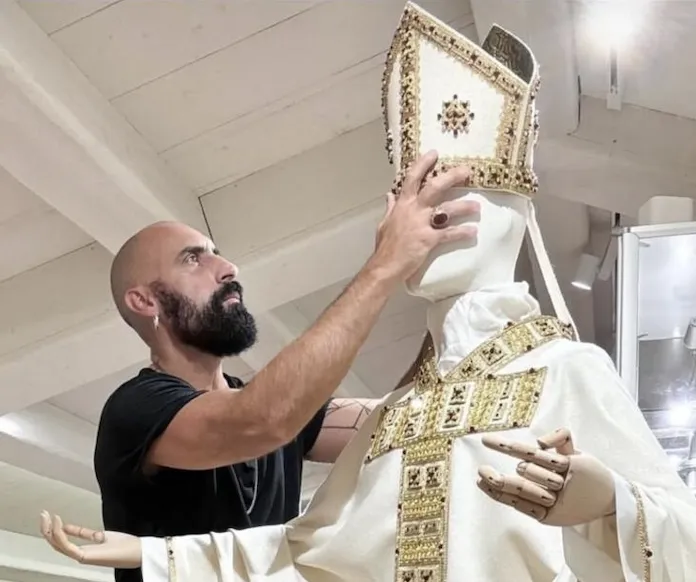 Acesta purta veșmintele somptuoase tradiționale, vrând să le arate oamenilor frumusețea și continuitatea istorică a Bisericii. A reintrodus camauro, mozzetta roșie cu hermină și mitre în stil renascentist. Toate aceste alegeri nu erau estetice, ci simboluri ale sacralității și continuității.