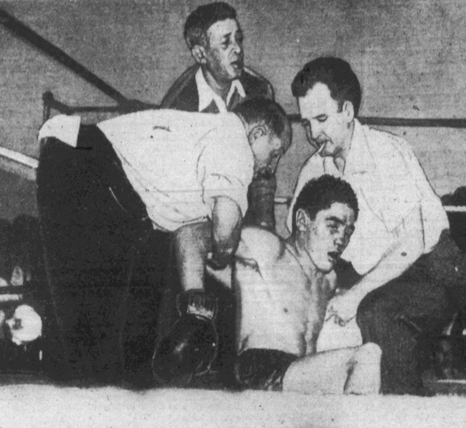 Jimmy Doyle (jos) este ridicat de pe podeaua ringului de trei bărbați, imediat după meciul său de box cu Sugar Ray Robinson. Momentul surprinde urmările directe ale KO-ului suferit, iar Doyle avea să moară câteva ore mai târziu într-un spital din Cleveland, din cauza rănilor suferite în luptă. (foto: Wikipedia)