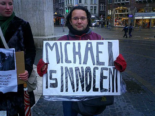 Un susținător al lui Jackson în Amsterdam, 2004, cu o pancartă pe care scrie „Michael e nevinovat”. (foto: Wikipedia)